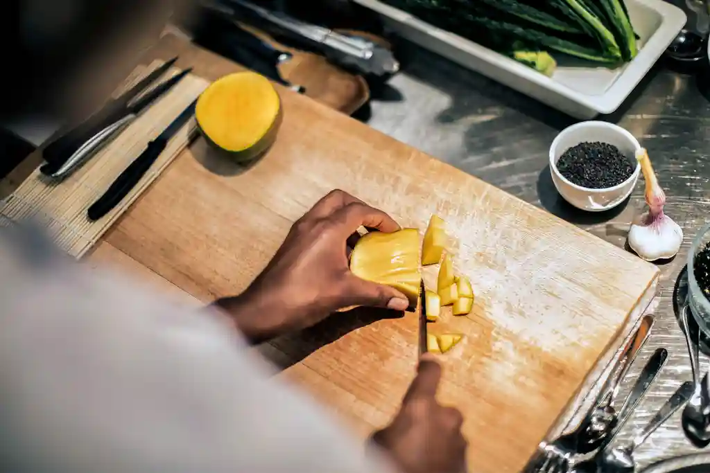 photo of woman cutting fruit on cutting board