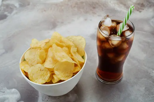 photo of a bowl of chips and a glass with soda