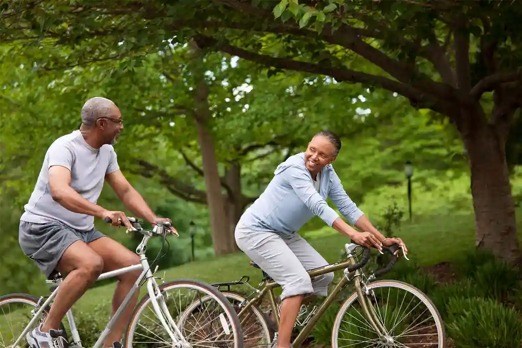 photo of couple riding bicycles in the park