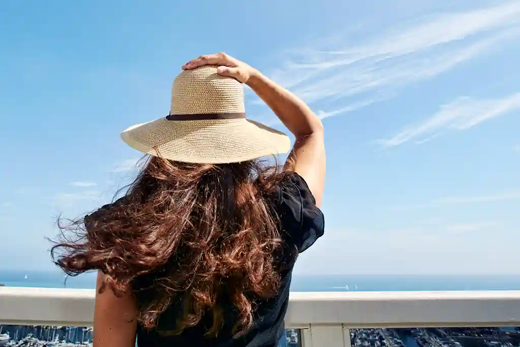 photo of woman in sun admiring view from balcony