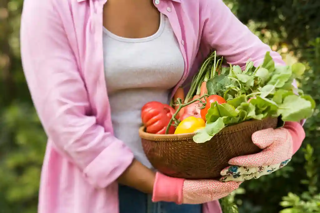 photo of woman carrying basket of fresh vegetables