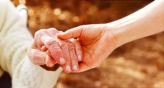caretaker holding hands with patient