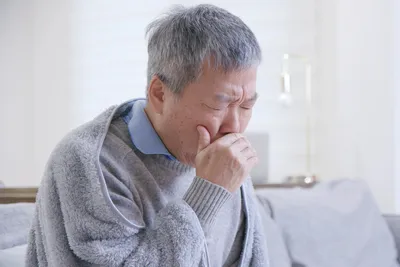 photo of coughing senior man