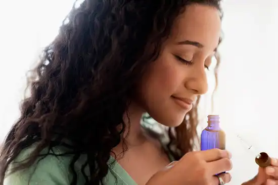 photo of woman smelling essential oil