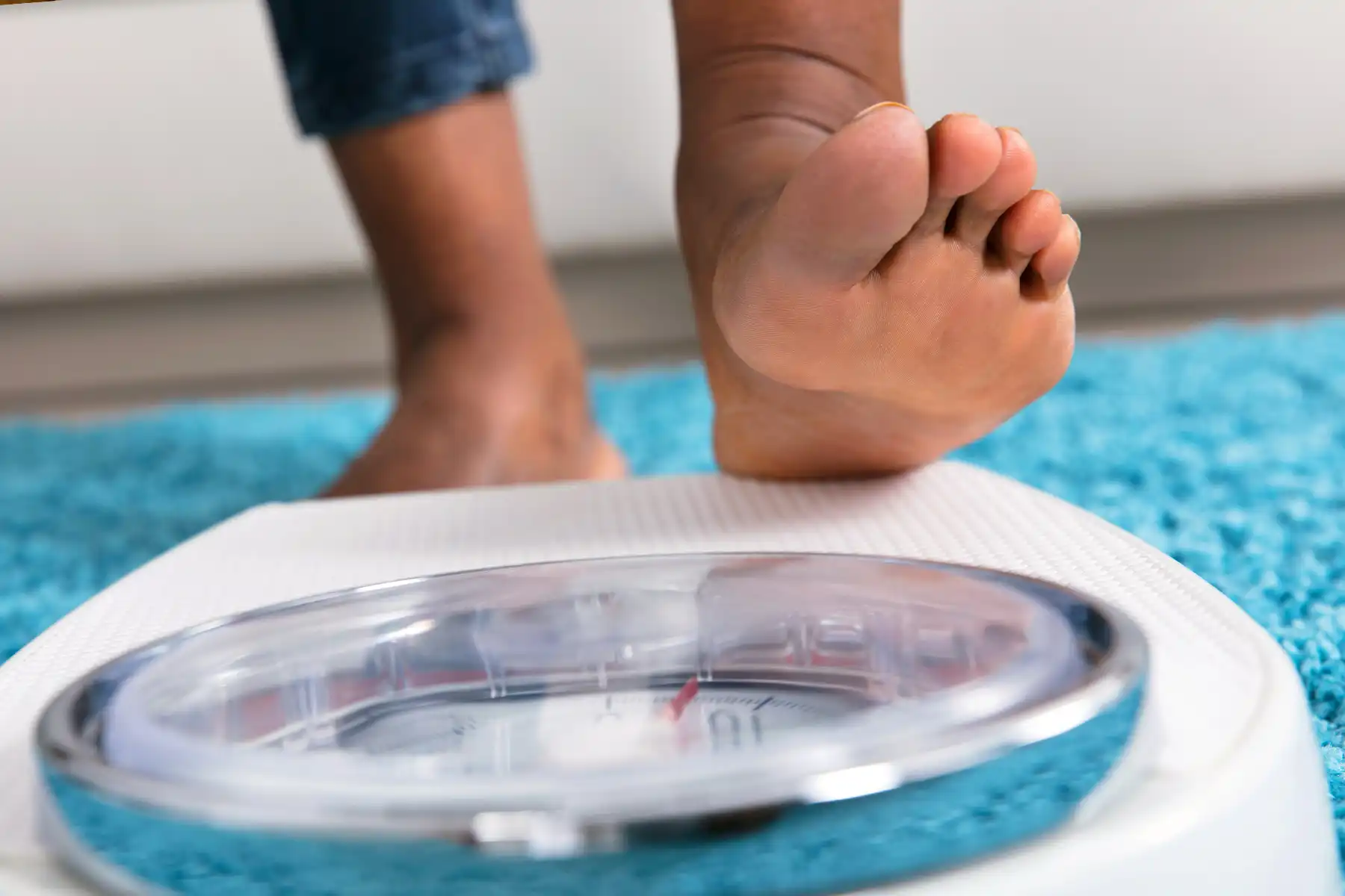 photo of man stepping on weight scale