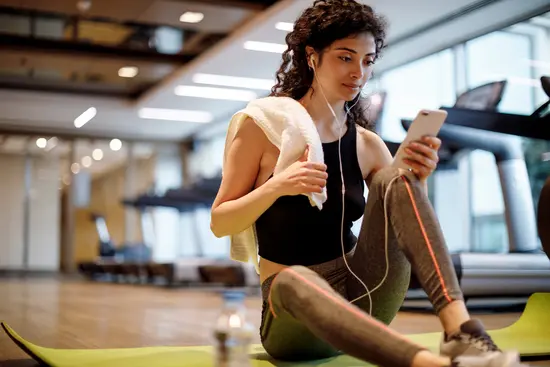 photo of woman using phone at gym