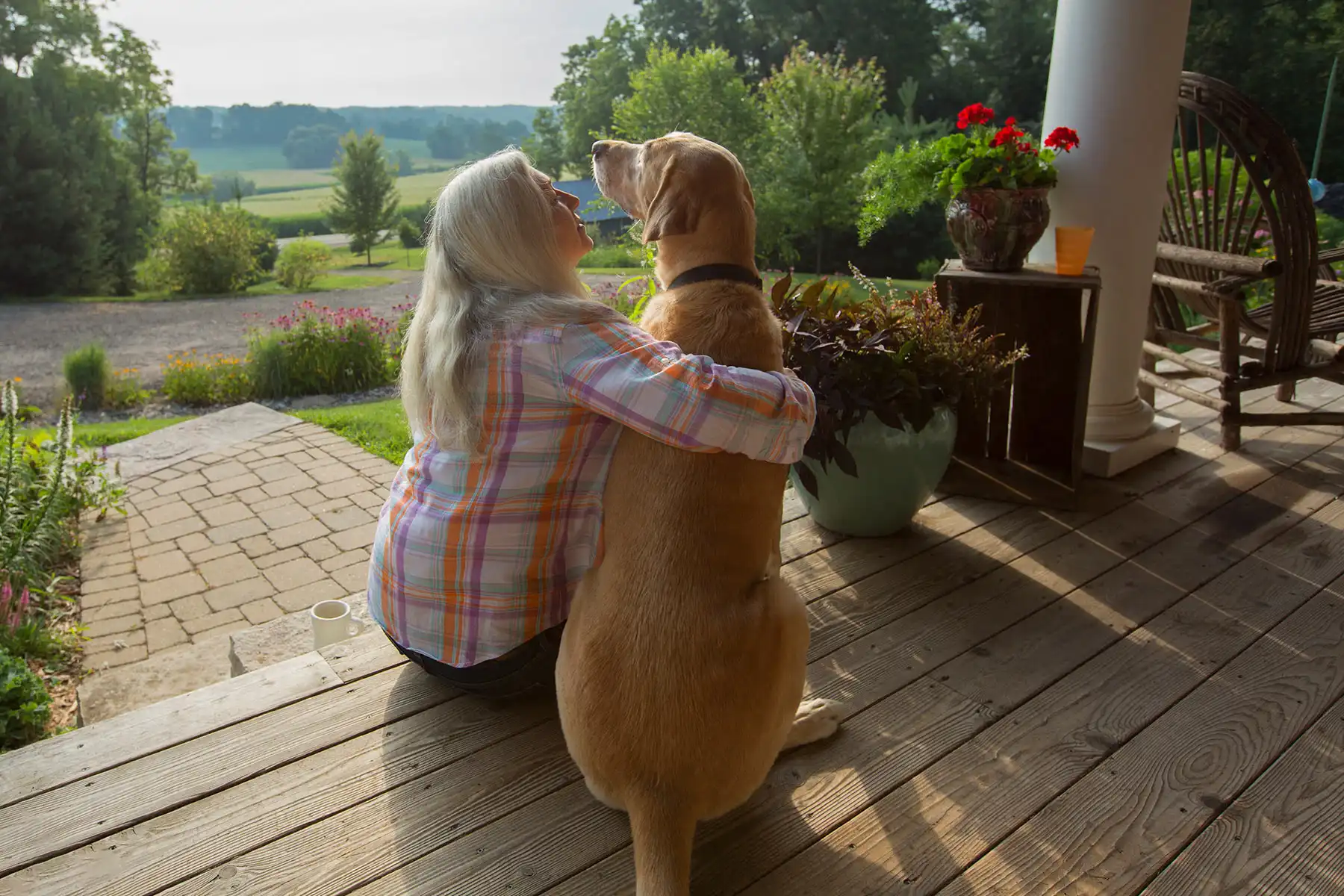 photo of mature woman with dog on front porch