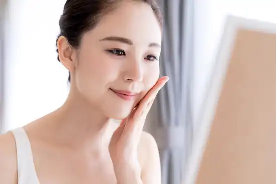 photo of young asian woman looking in mirror