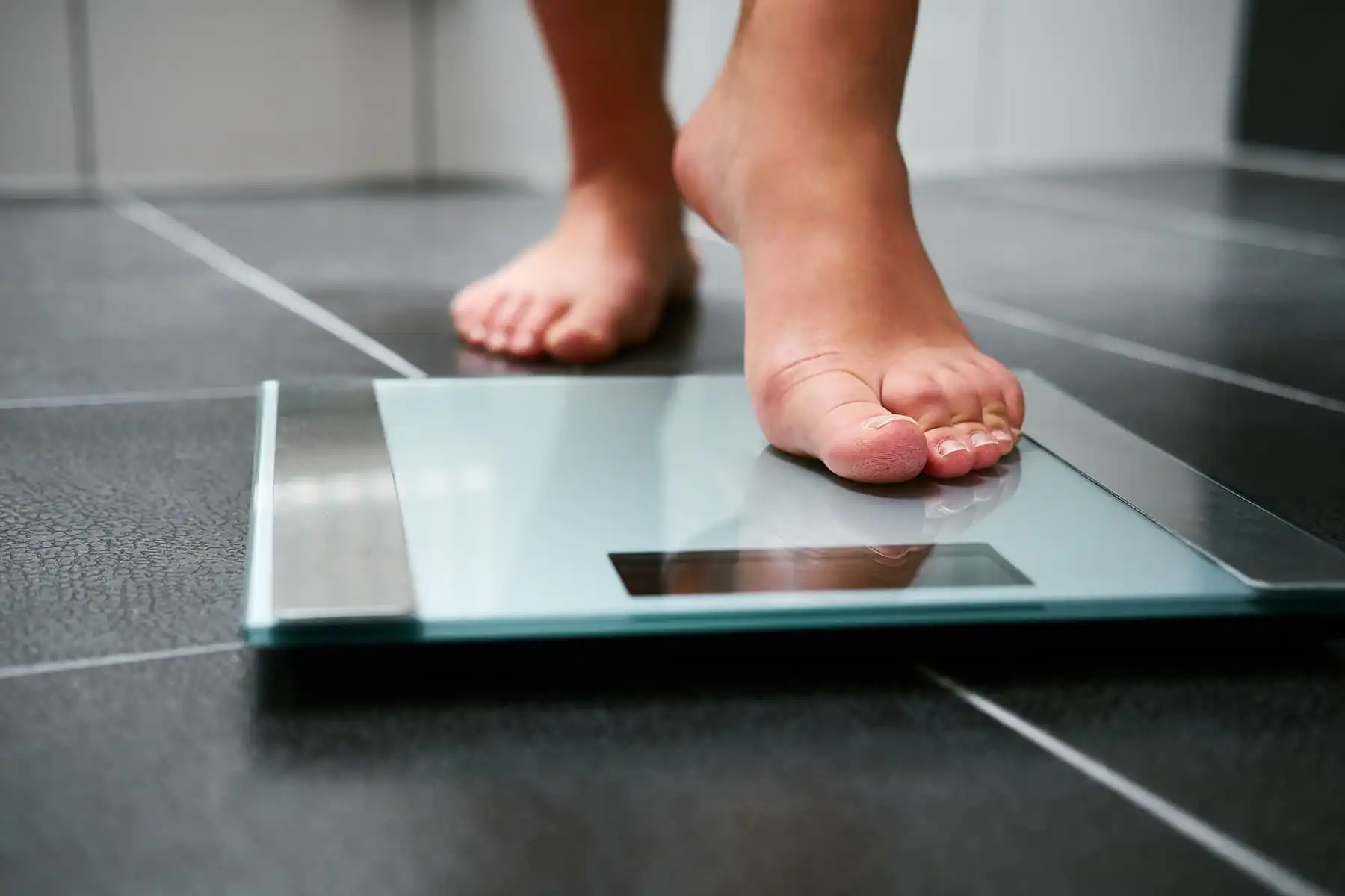 person stepping onto scale