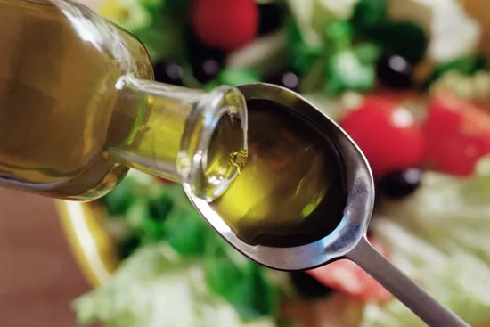 photo of olive oil pouring on to a spoon