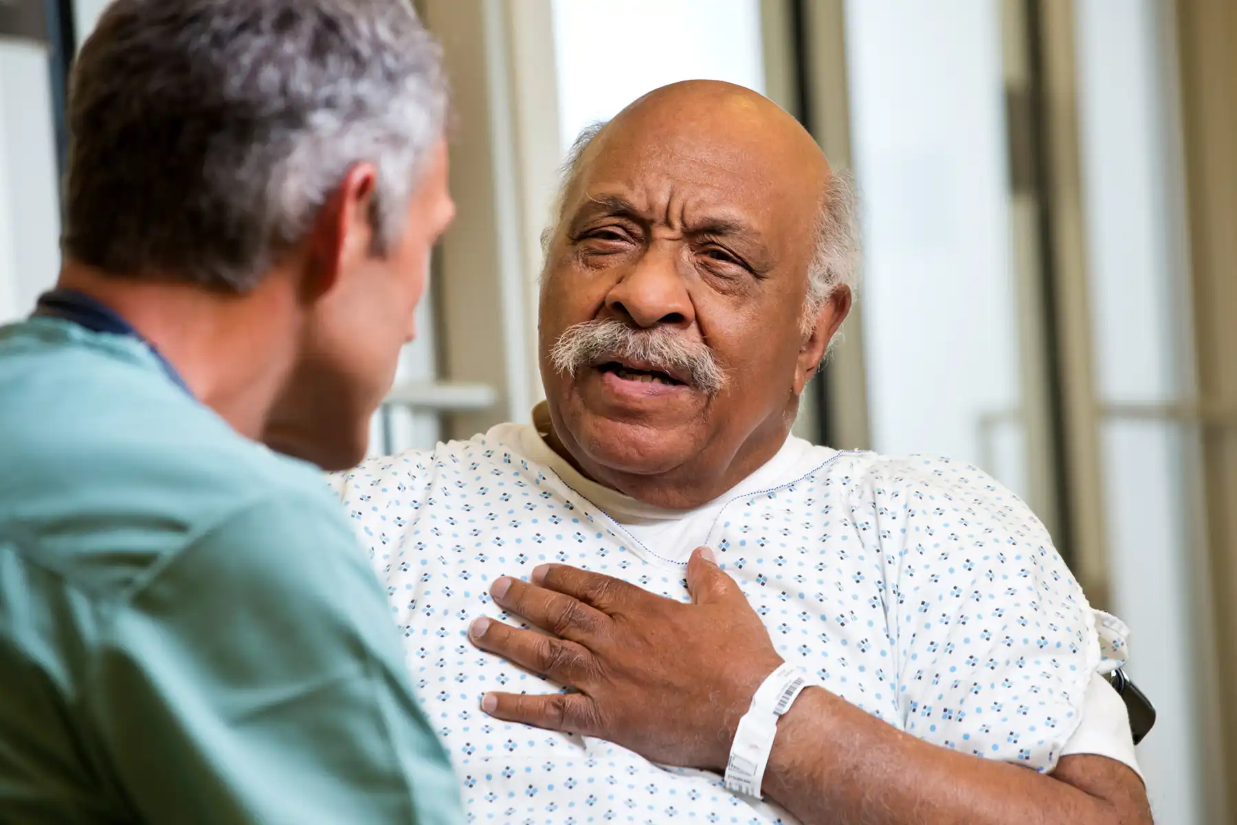 photo of senior describing chest pain to doctor