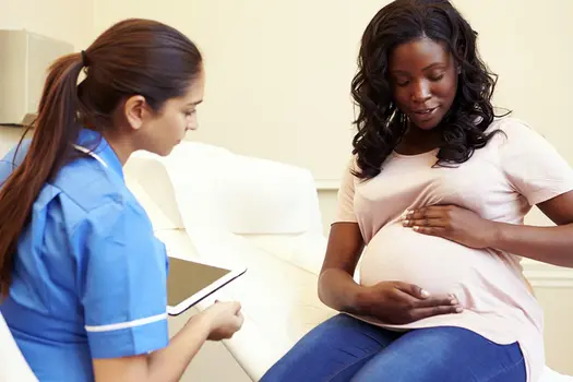 photo of pregnant woman talking with nurse