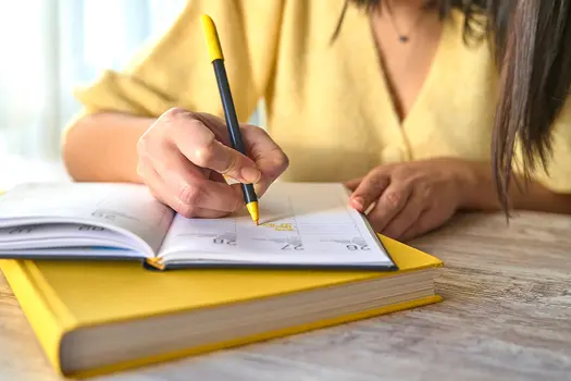 photo of woman writing in a planner