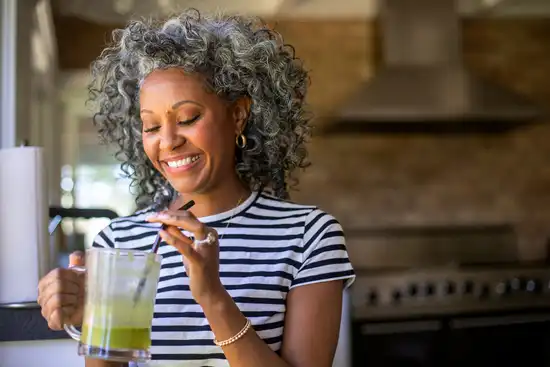photo of woman drinking green smoothie