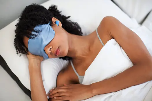 photo of woman sleeping with mask and earplugs